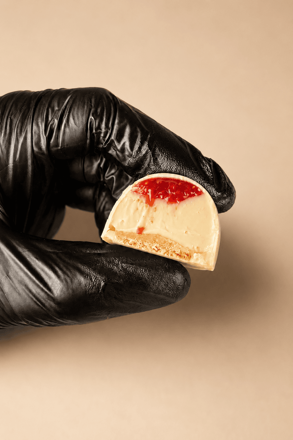 Bombom Cheesecake de Morango da Saito Chocolatier — corte revelando morango e cream cheese