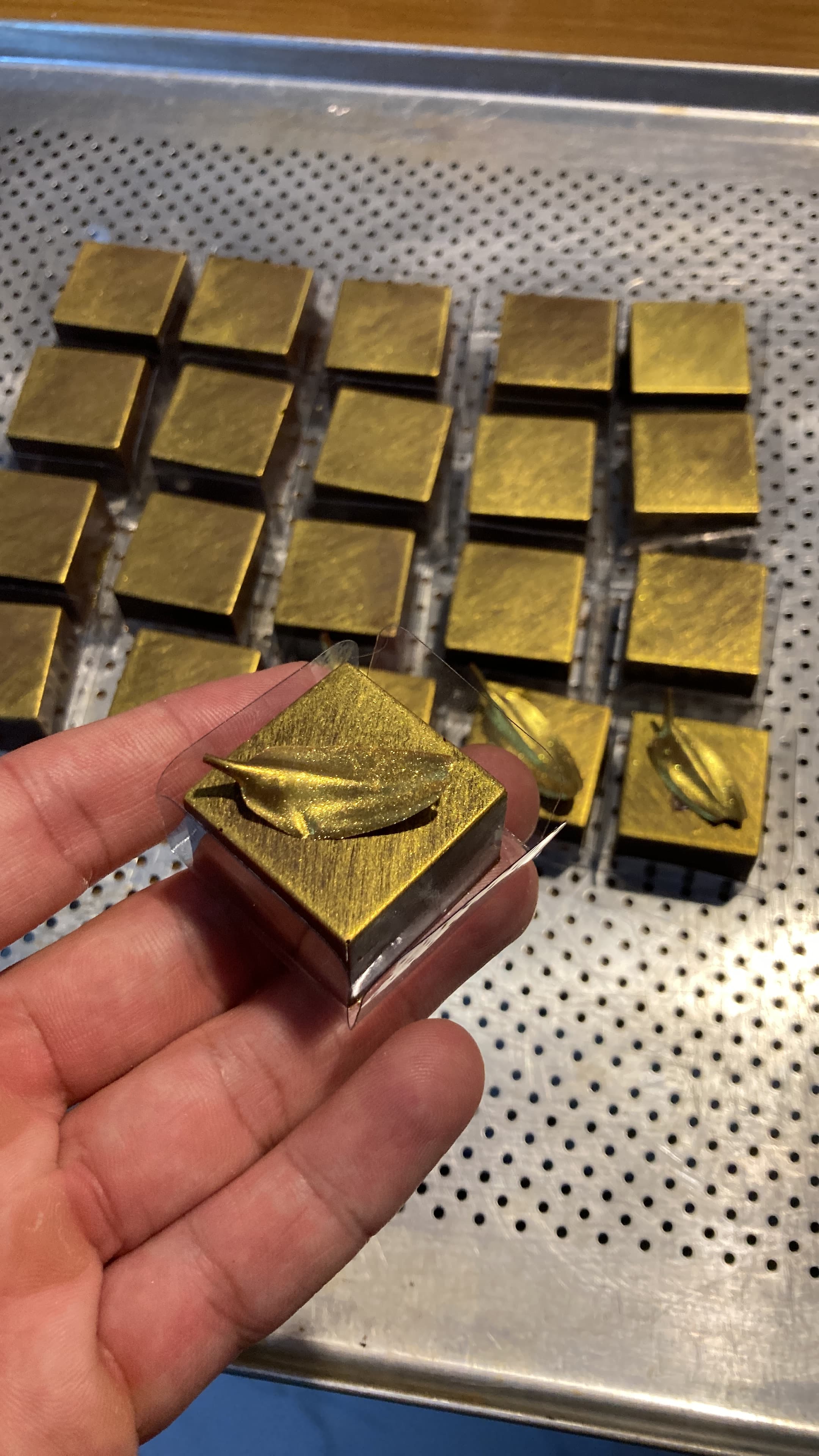 Bombons decorativos dourados sendo produzidos no ateliê Saito